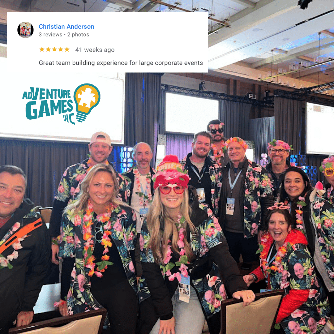 A smiling group of Adventure Games Inc. team-building participants pose together indoors wearing matching black floral jackets, leis, and fun accessories. They are standing in front of a conference stage with lights and screens in the background. A five-star Google review by Christian Anderson is displayed at the top left, reading, “Great team building experience for large corporate events.” The Adventure Games Inc. logo with a lightbulb icon appears on the left side of the image.