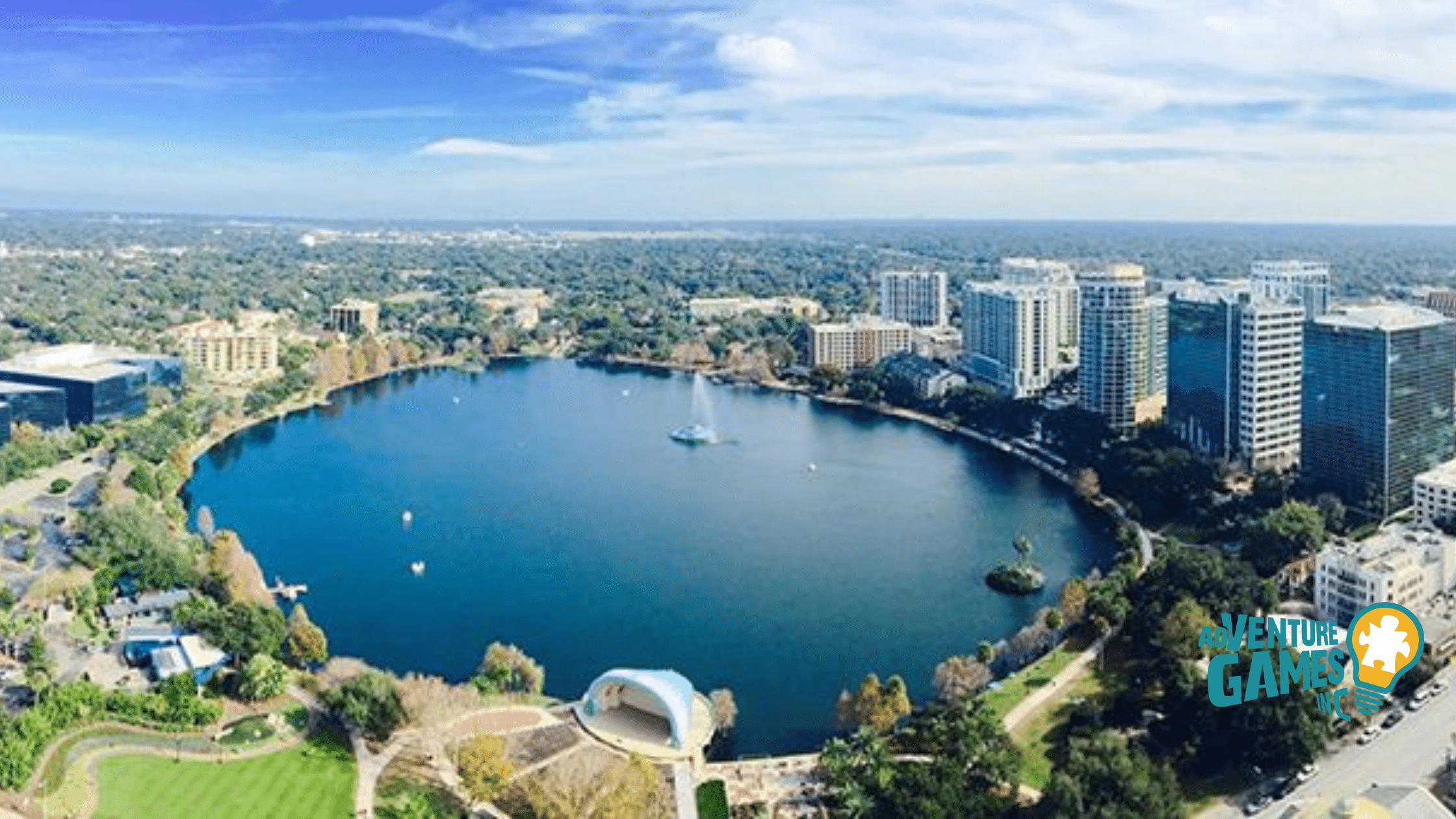 Aerial view of Lake Eola Park in downtown Orlando Florida with its central fountain, swan boats and surrounding skyline providing a scenic backdrop for outdoor team building activities