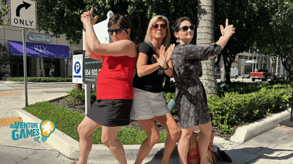 Three coworkers strike playful secret agent poses on a sidewalk during a SpyGame team building challenge led by Adventure Games Inc.