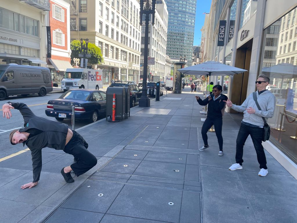 Teams strike playful freeze-frame poses in downtown San Francisco, highlighting creativity and collaboration during an Adventure Games Inc. challenge.