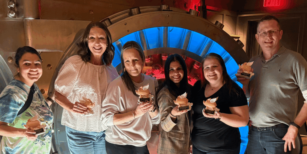 A smiling corporate team poses with trophies during an Adventure Games Inc. team-building event, showcasing the collaborative and engaging experiences described in “What Is Adventure Games Inc? A Complete Guide to the Nation’s Top Team-Building Company.”