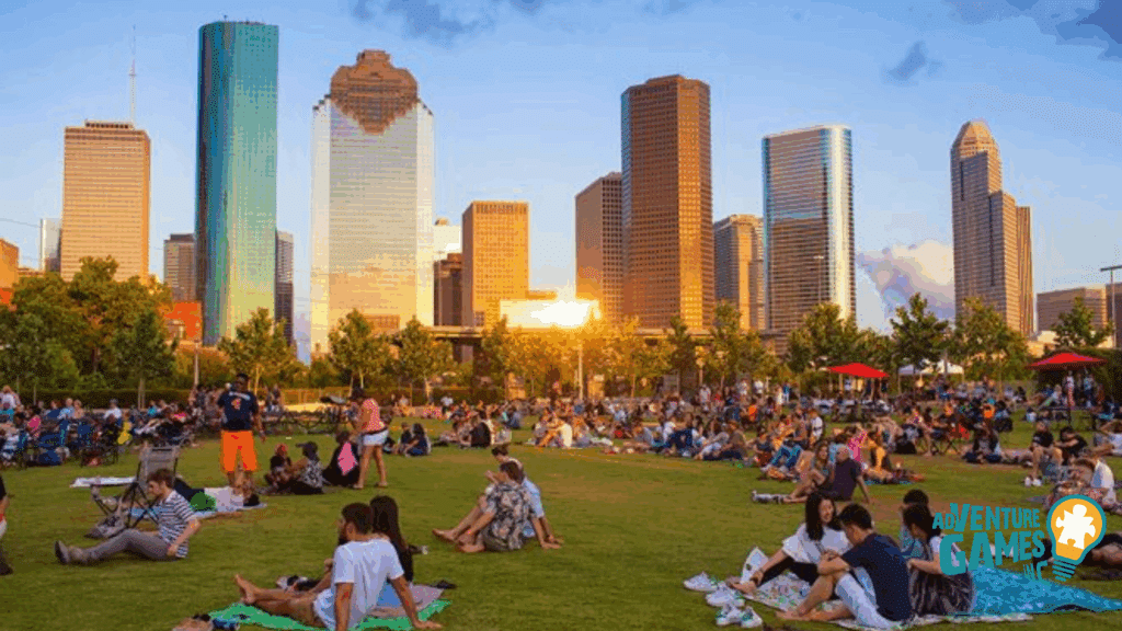 Crowds relaxing on the lawn at Buffalo Bayou’s Eleanor Tinsley Park with the Houston skyline at sunset.