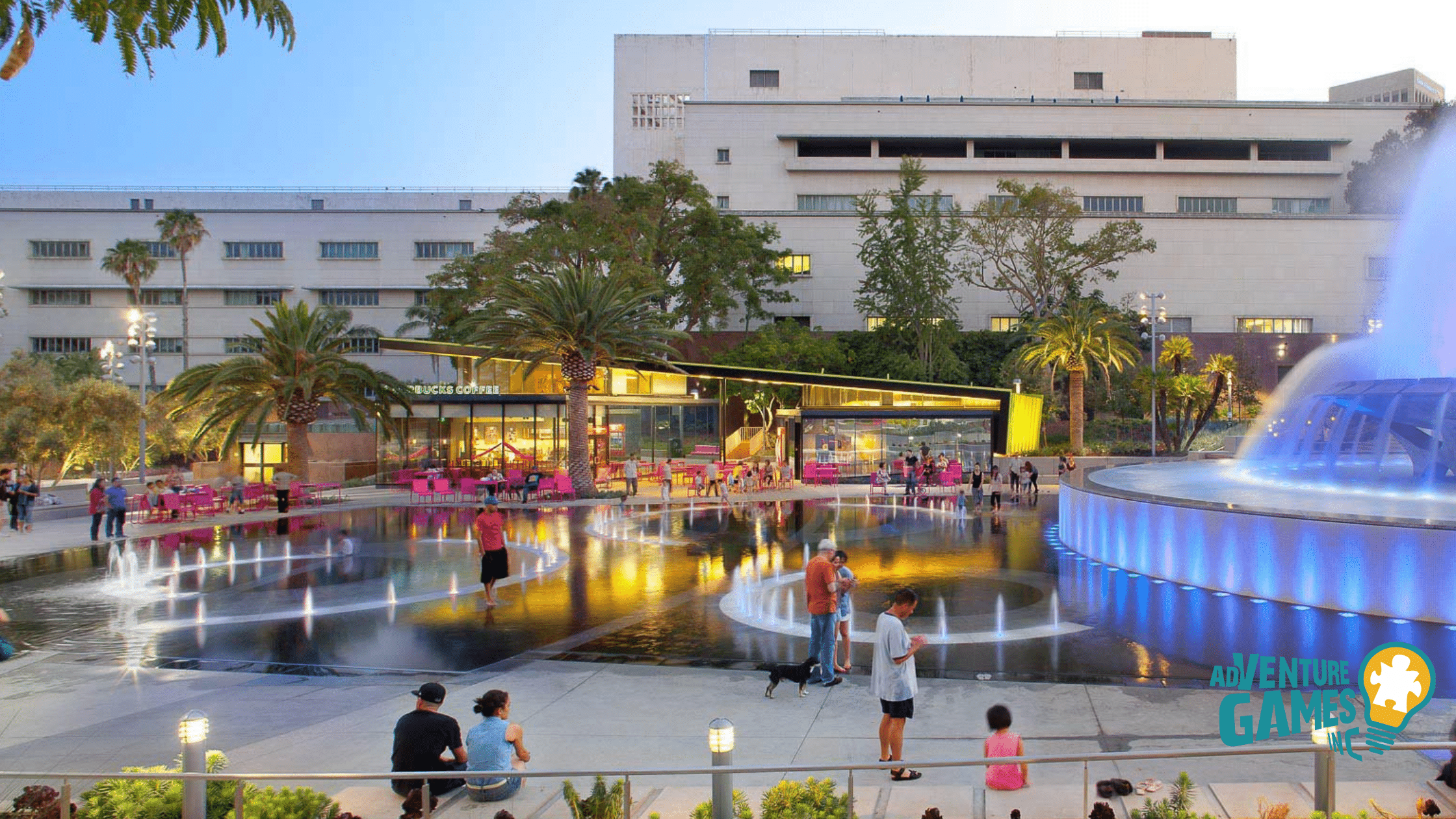Grand Park in Los Angeles with families enjoying the colorful fountain plaza, palm trees, and a lively evening atmosphere – Adventure Games Inc team building spot.