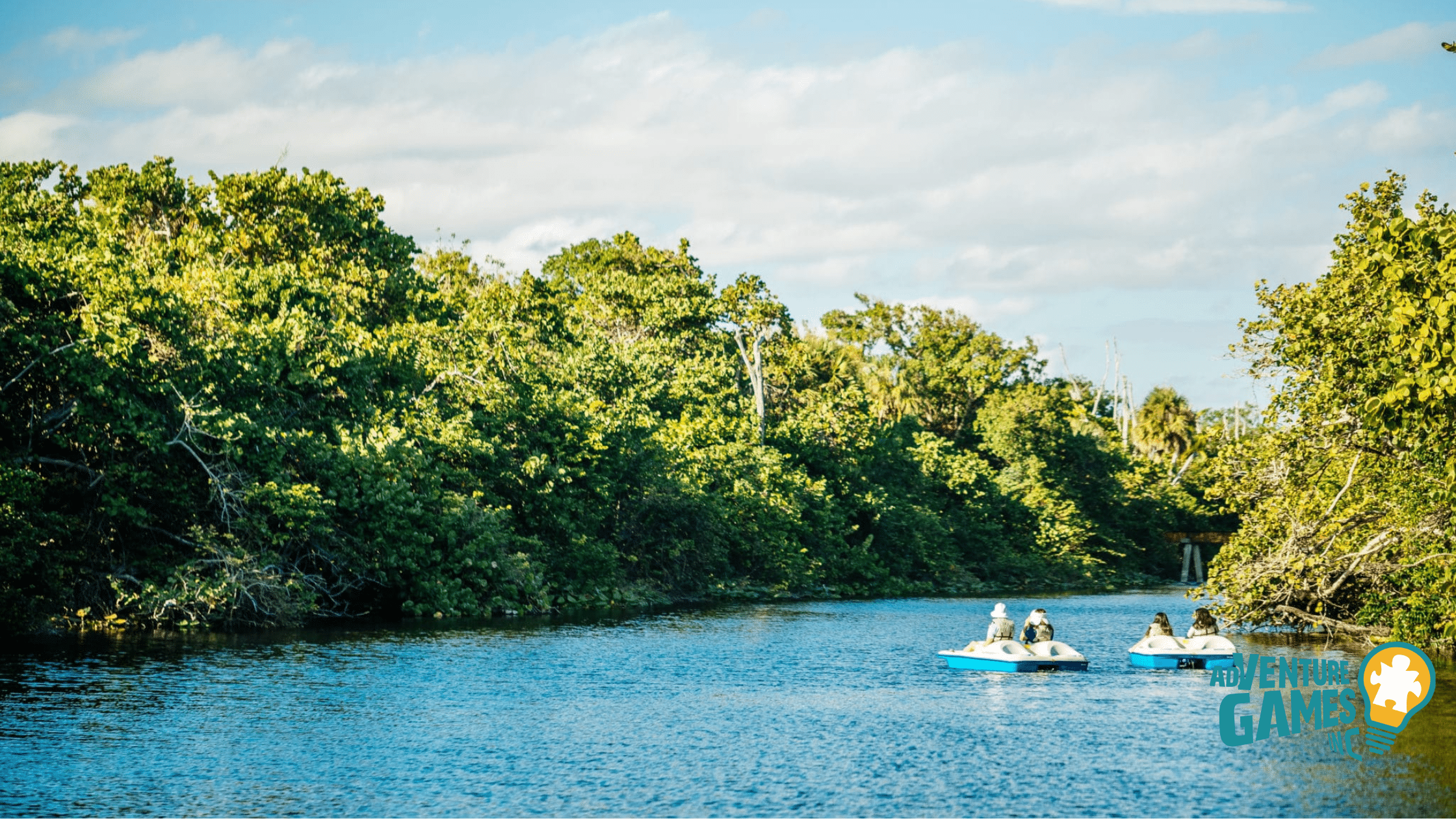 Adventure Games Inc team building at Hugh Taylor Birch Park in Fort Lauderdale, featuring pedal boats on the water surrounded by lush greenery.