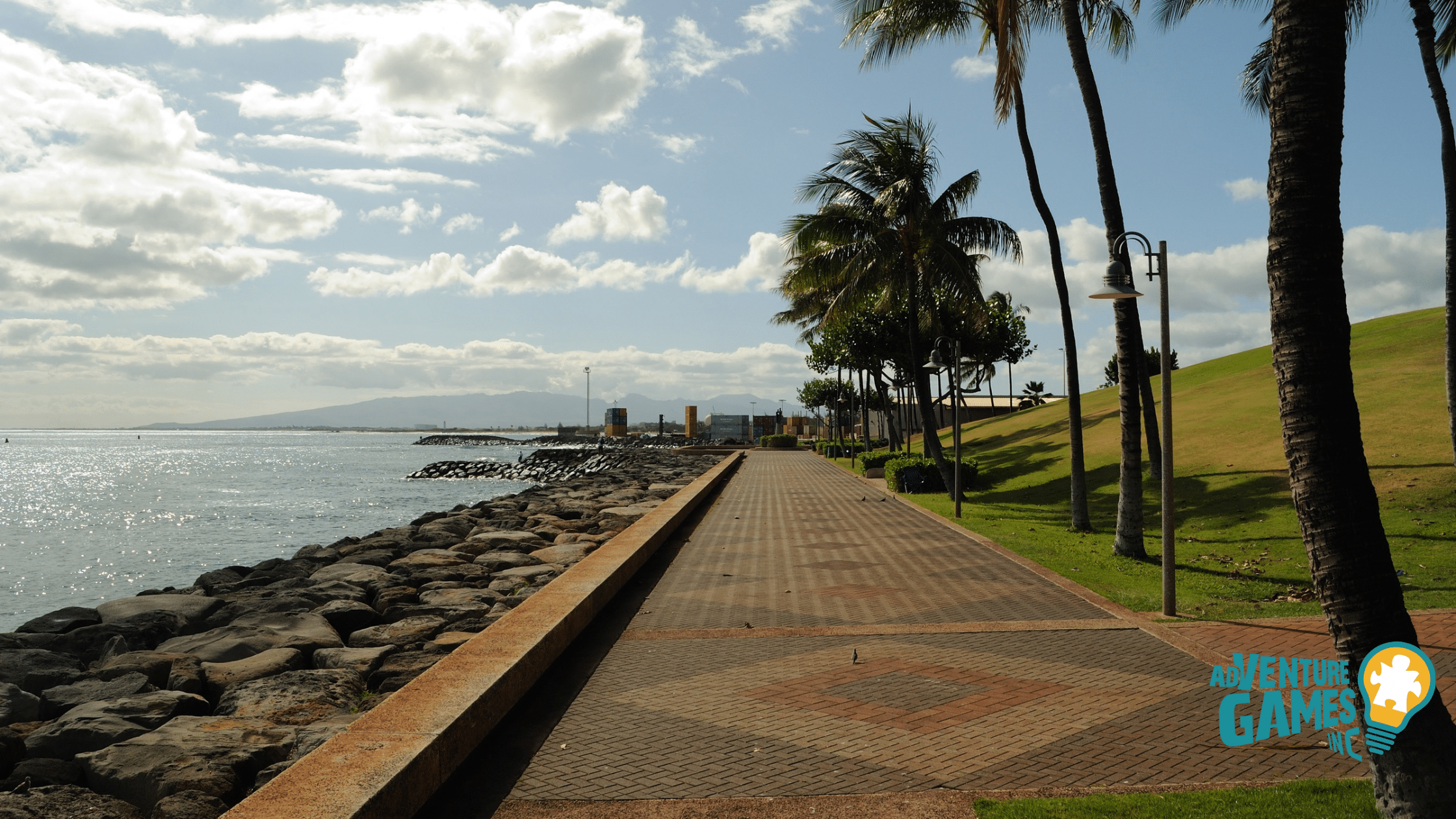 Scenic walkway at Kakaʻako Waterfront Park in Honolulu, Hawaii lined with palm trees overlooking the Pacific Ocean – Adventure Games Inc team building in Hawaii.