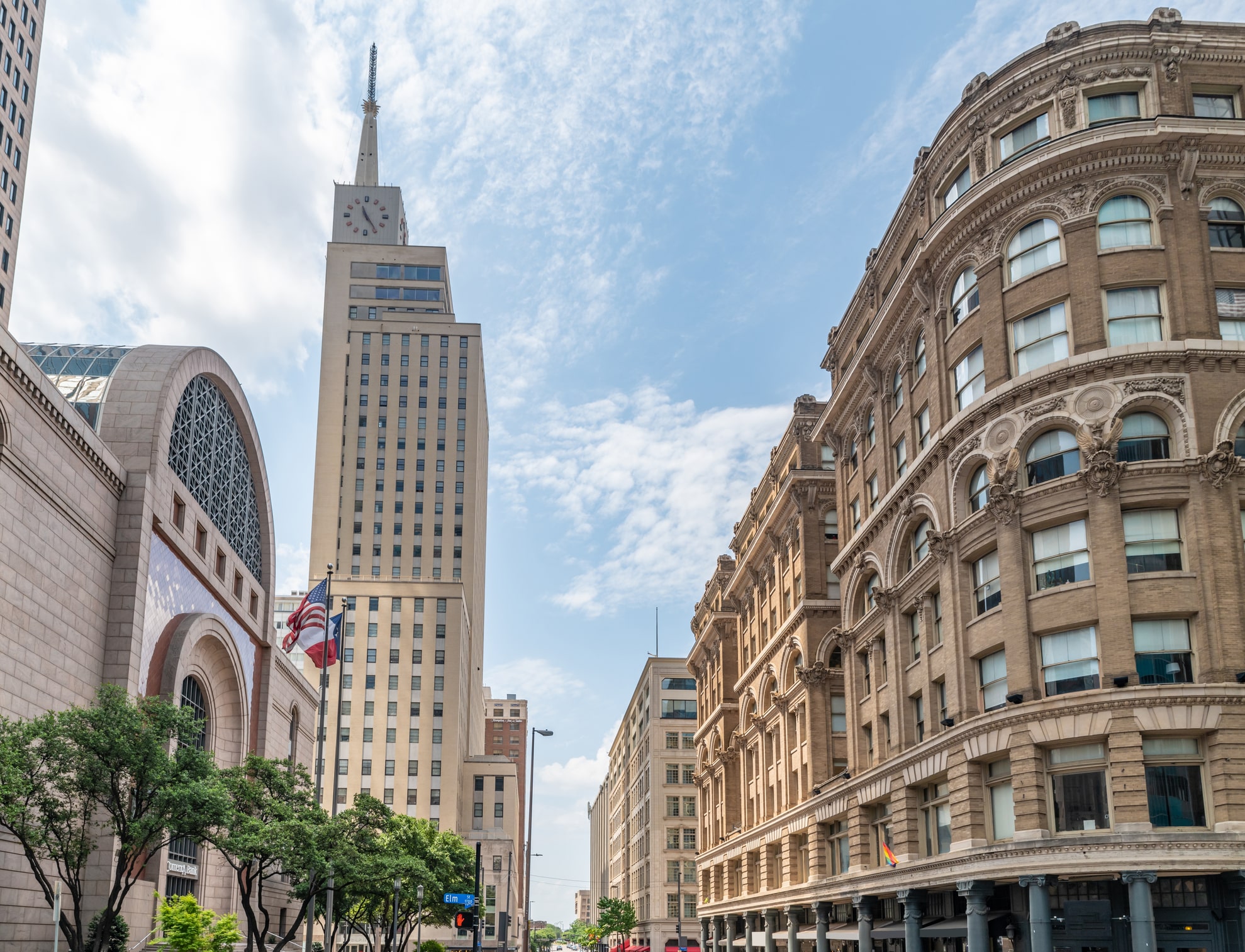 Aerial of Klyde Warren Park with green lawns above the freeway and downtown skyscrapers, a popular location for outdoor team building in Dallas.