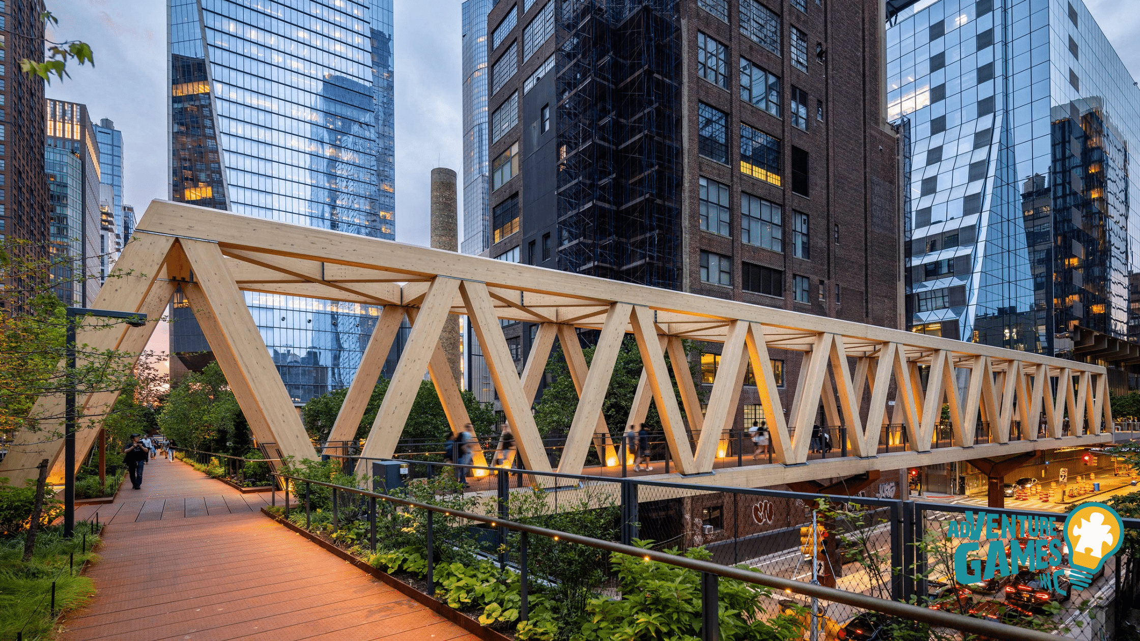 Timber-truss pedestrian bridge linking the High Line to Hudson Yards, framed by glass towers at dusk.