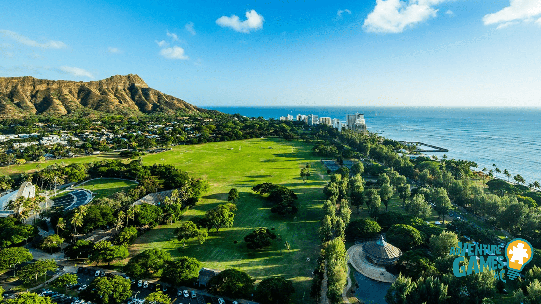 Queen Kapiʻolani Park in Waikīkī, Honolulu with Diamond Head crater in the background and open green fields by the ocean – Adventure Games Inc best team building Hawaii.