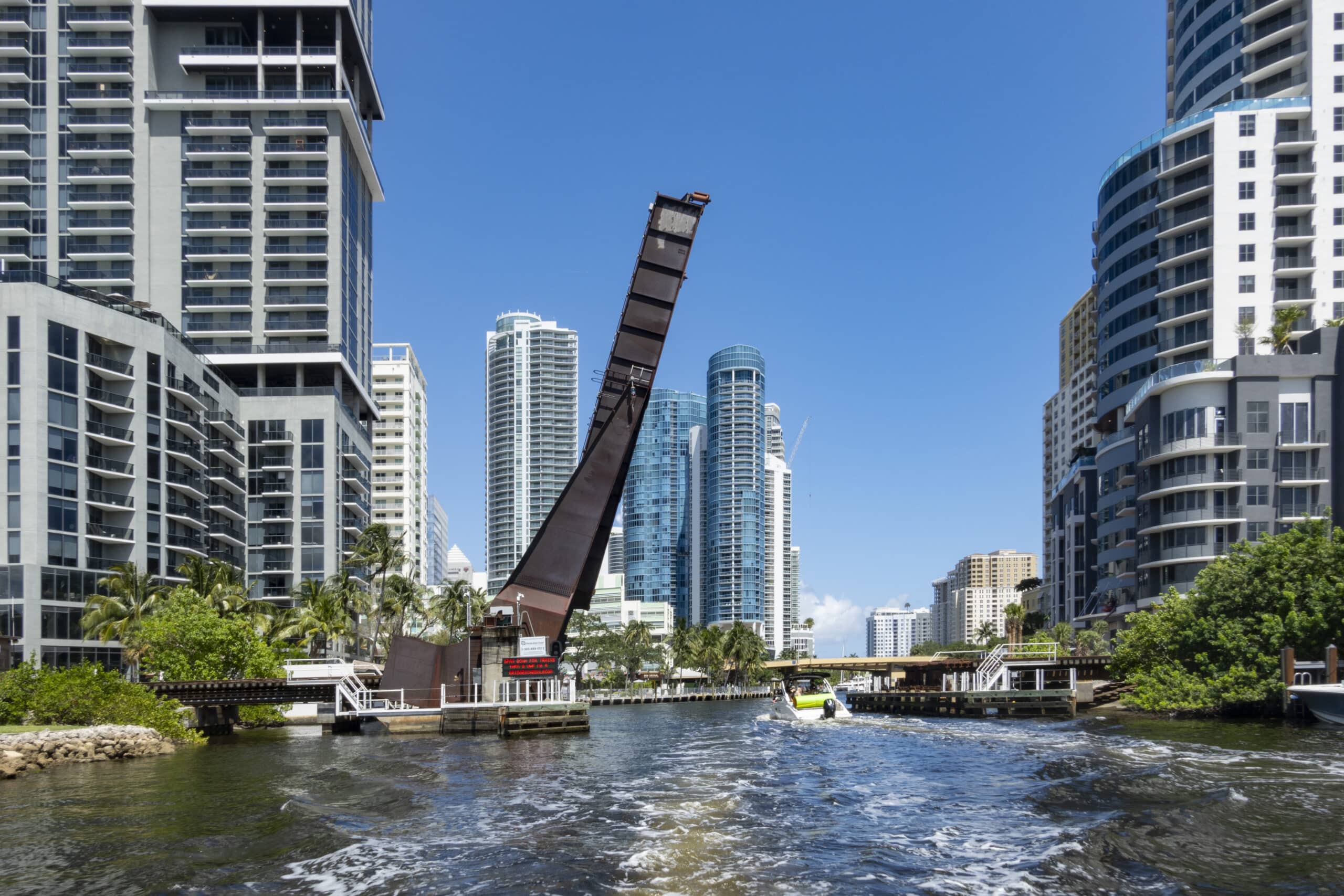 Adventure Games Inc team building at Riverwalk Fort Lauderdale and Esplanade Park, with a bridge, palm trees, and buildings lining the waterway.