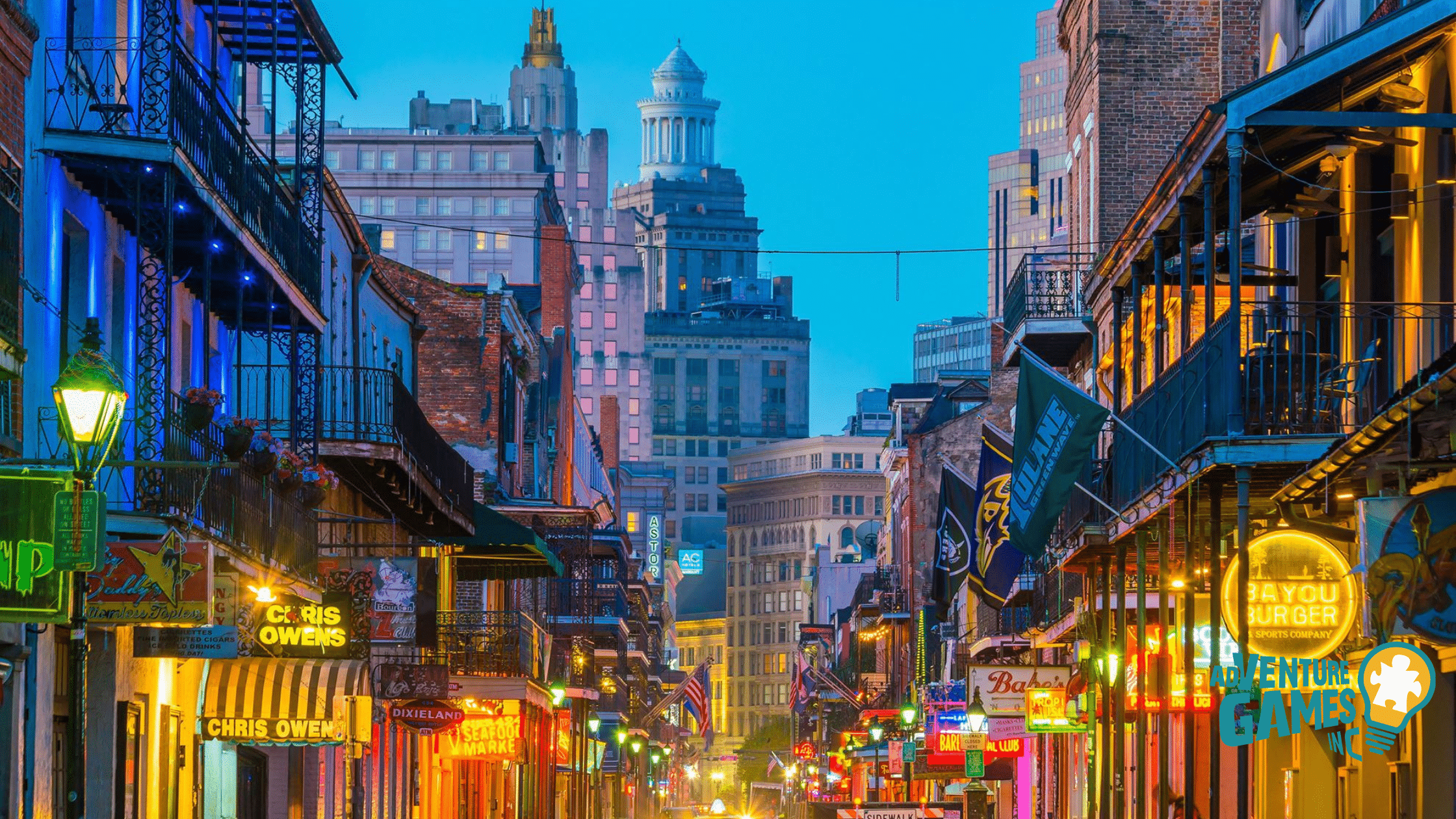 Bourbon Street at dusk in New Orleans with neon signs, wrought-iron balconies and the downtown skyline—vibrant French Quarter scene for team building.”
