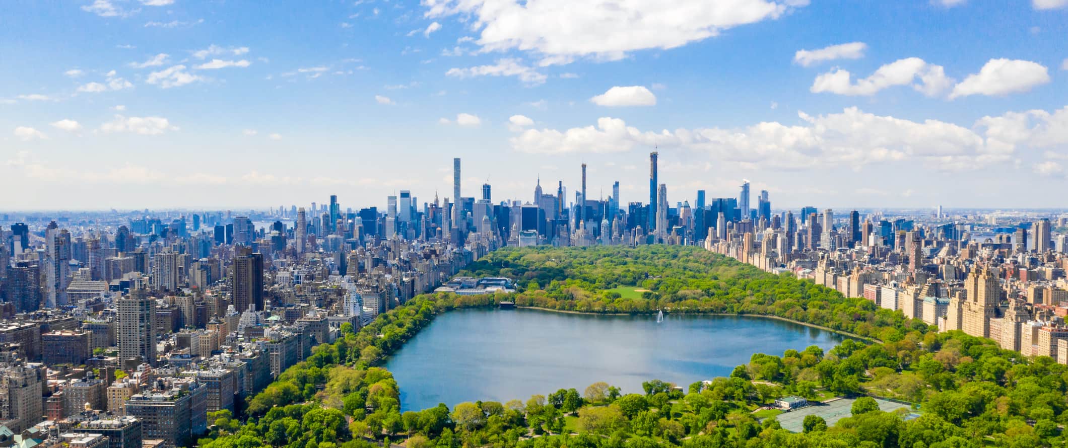 Aerial panoramic of Central Park and the Manhattan skyline with the Jacqueline Kennedy Onassis Reservoir—clear day, ideal backdrop for NYC team-building events.