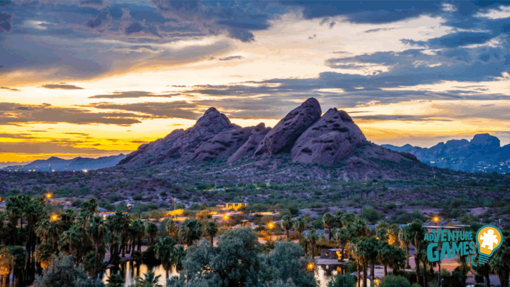 Papago Park at sunset with red sandstone buttes rising over palm-lined desert scenery.