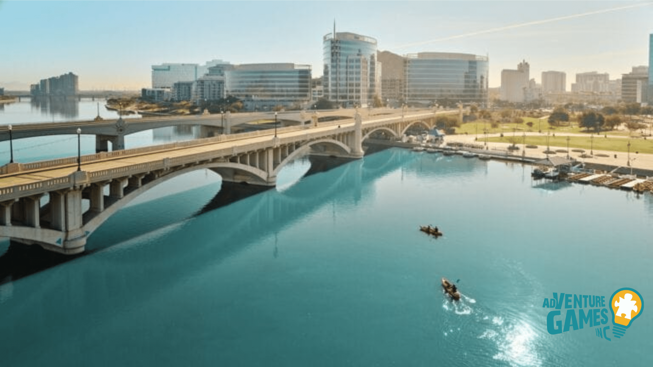 Tempe Town Lake and Beach Park with arched bridges, kayakers on blue water, and modern Tempe skyline.